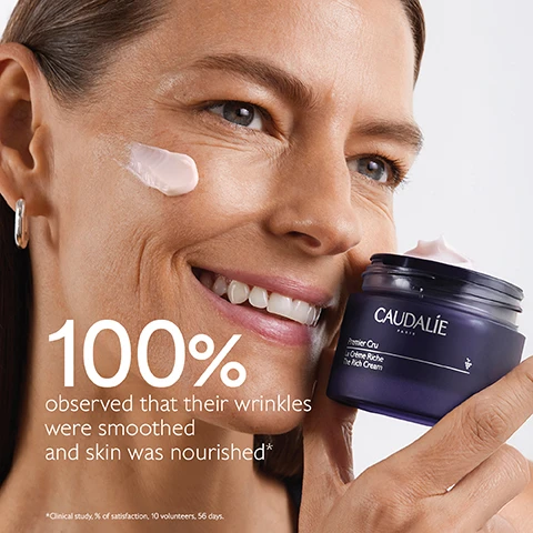 Image 1 - A woman with a smile applies cream to her cheek while holding a jar of Caudalie Premier Cru The Rich Cream, with the text stating 100% observed that their wrinkles were smoothed and skin was nourished.
Image 2 - A purple background features a jar of Caudalie Premier Cru La Crème Riche with cream spilling out, surrounded by dark grapes, and includes text that reads Natural plumping filler, Improves skin volume, Longevity patent, Stimulates youth proteins, Bio-ceramides, Replenish and protect skin barrier.
Image 3 - A woman with long brown hair smiles while holding a bunch of dark grapes, with visible text saying Targets all signs of ageing followed by check marks for Wrinkles, Dark spots, and Volume.
Image 4 - Image shows two jars of CAUDALIE skincare products labeled The Cream and The Rich Cream side by side against a textured background, with features listed for each: The Cream addresses wrinkles, dark spots, volume, suitable for all skin types, with a cream texture; The Rich Cream addresses wrinkles, dark spots, volume, suitable for dry skin, with a rich texture.
Image 5 - A dark purple background features two jars of Caudalies Premier Cru The Rich Cream, with visible text stating New Premier Cru The Rich Cream, New longevity formula, New natural plumping filler from rosewood.
Image 6 - A series of four skincare creams displayed on a purple background, labeled from top to bottom as The Serum, The Cream, The Rich Cream, and The Eye Cream.
Image 7 - A hand holding a jar of cream with a purple lid and a small container of refill cream, accompanied by text instructions on recycling the creams packaging that reads: How to recycle Premier Cru The Rich Cream 1 Keep the glass jar and the cover 2 Recycle the empty refill in the recycling bin 3 Insert a new refill into your jar.